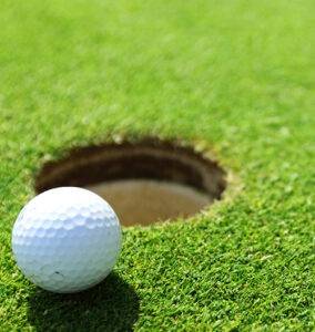 Golf ball on the edge of a hole